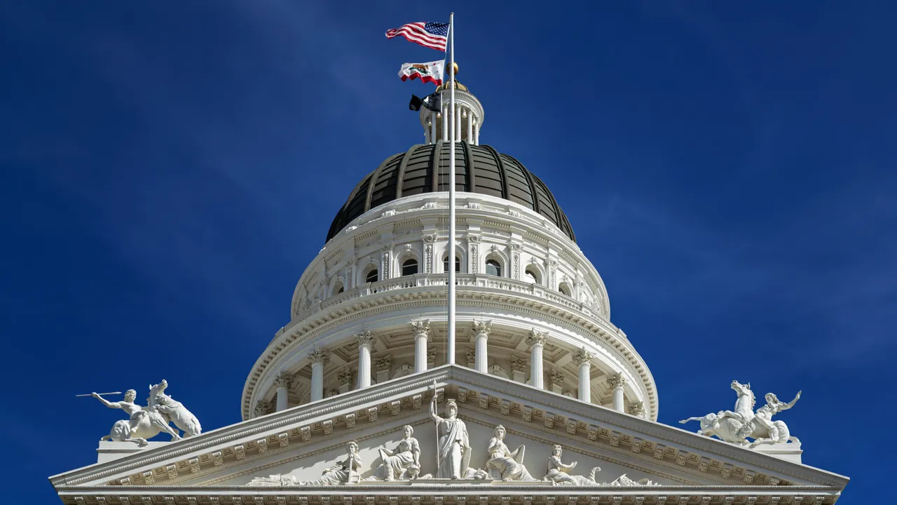 The dome and pediment of the California State Capitol in Sacramento against a blue sky