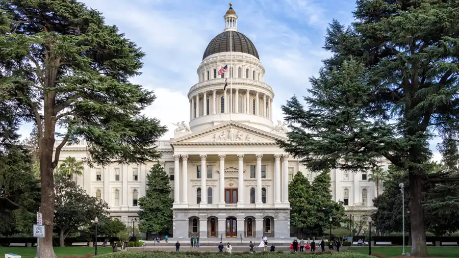 The California State Capitol building in Sacramento, framed by trees