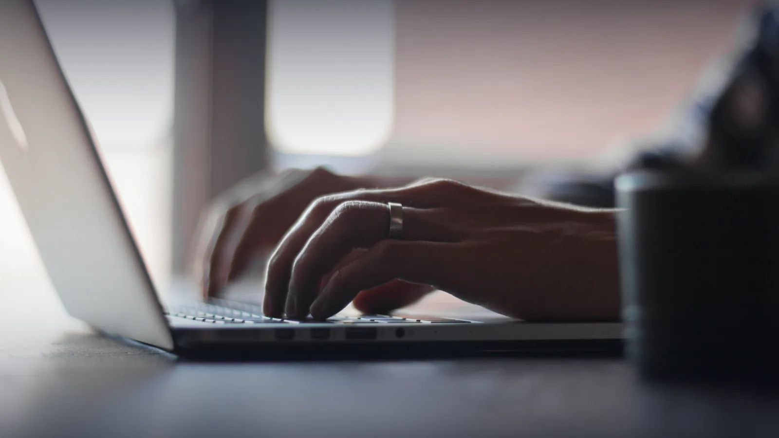 Hands typing on a laptop keyboard