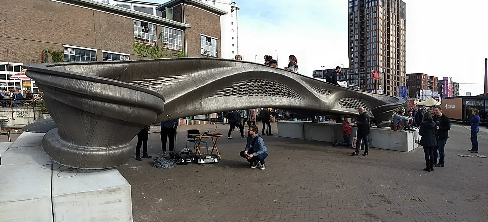 The MX3D 3D-printed steel bridge on display at Dutch Design Week, an organically shaped metal span with people walking across it