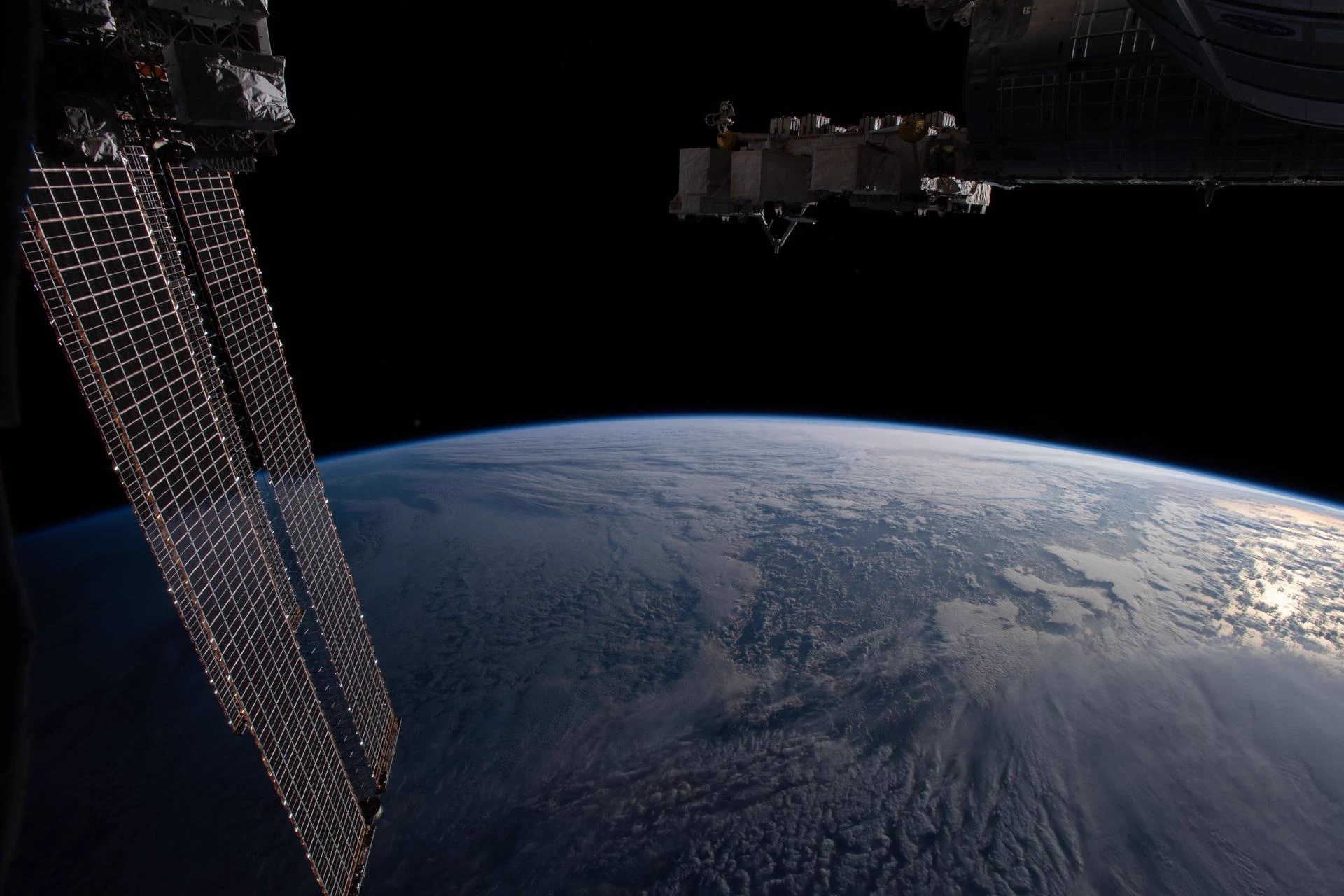 The International Space Station above Earth's limb, with its solar arrays catching sunlight