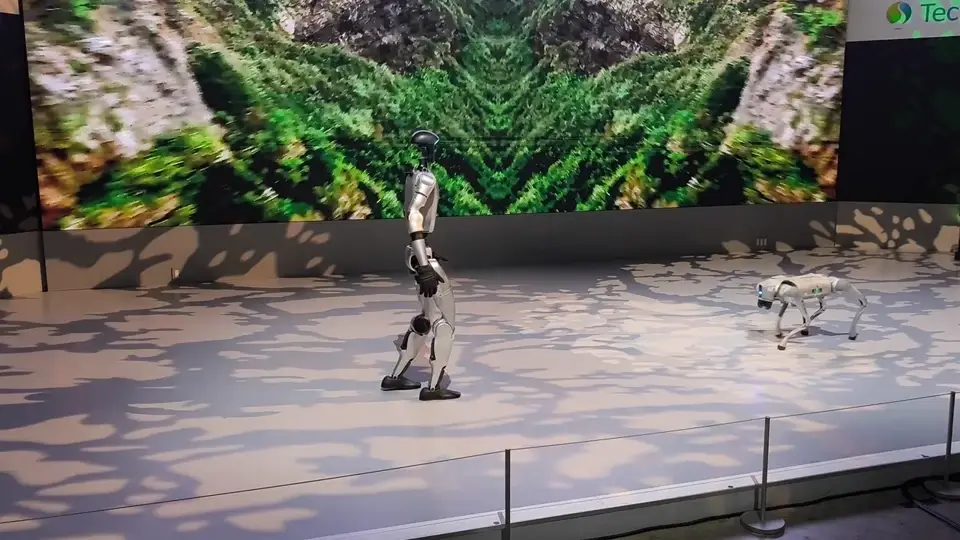 A Unitree G1 humanoid robot walking on stage at the Japan Mobility Show 2025