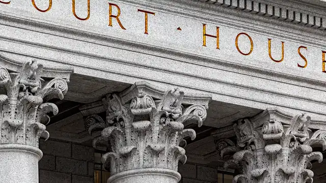 Stone columns and the words Court House carved on a courthouse facade