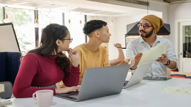 Office workers at desks with laptops in a modern workplace
