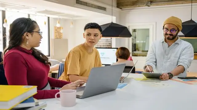 Employees working on laptops in a modern office
