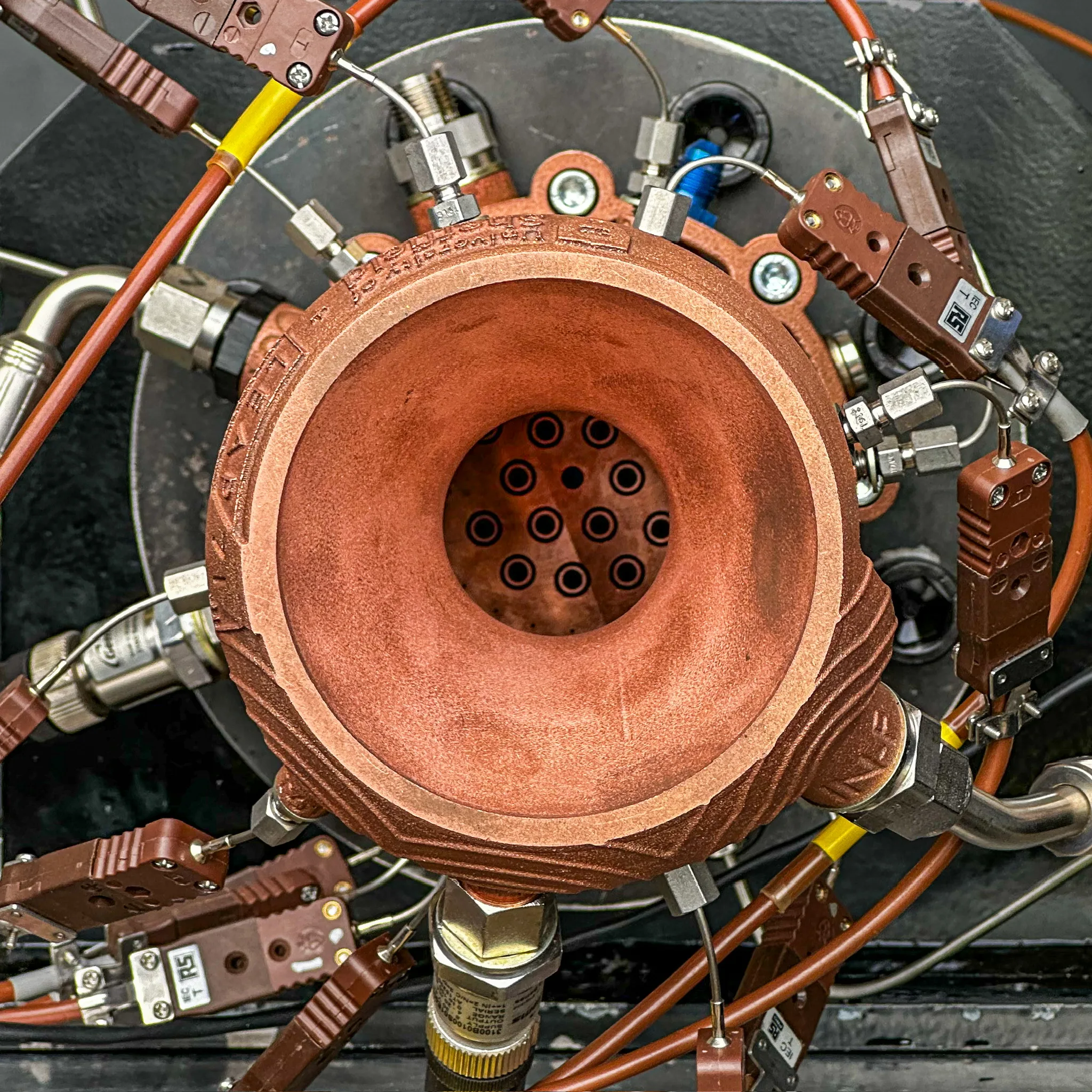LEAP 71’s Noyron-designed TKL-5 rocket thruster, 3D-printed in copper, with test instrumentation attached
