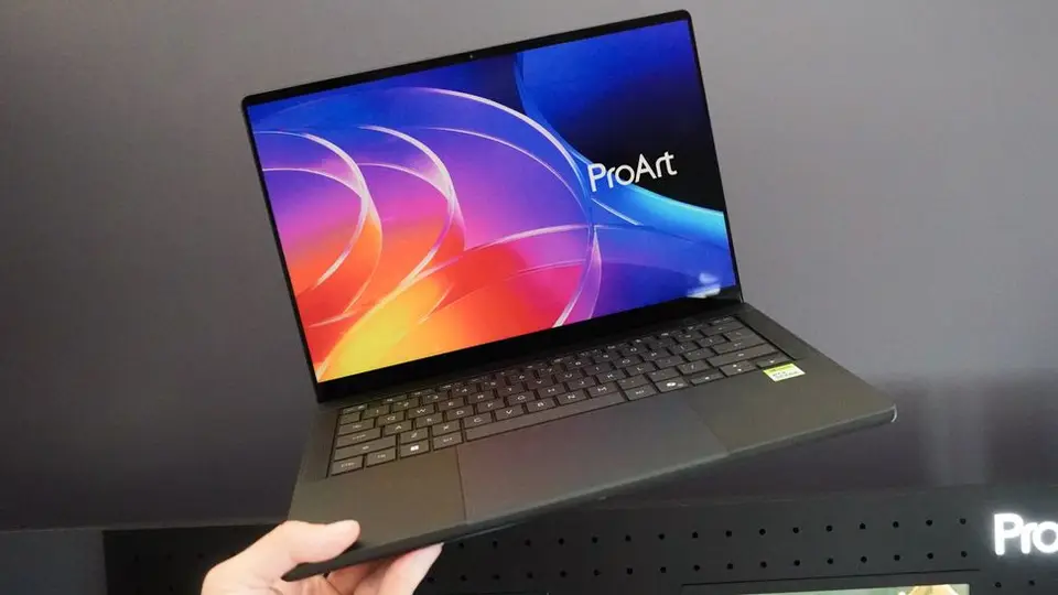 A hands-on photo of the ASUS ProArt P16, an RTX Spark laptop with a colorful ProArt wallpaper on screen