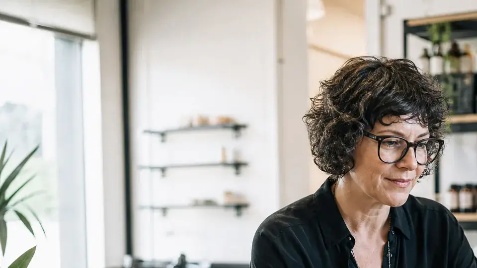 A small business owner at a laptop surrounded by connected app icons