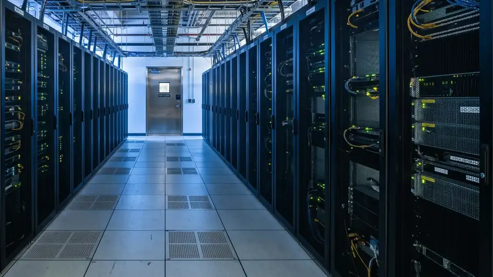 Close-up of server racks glowing in a dark data center aisle