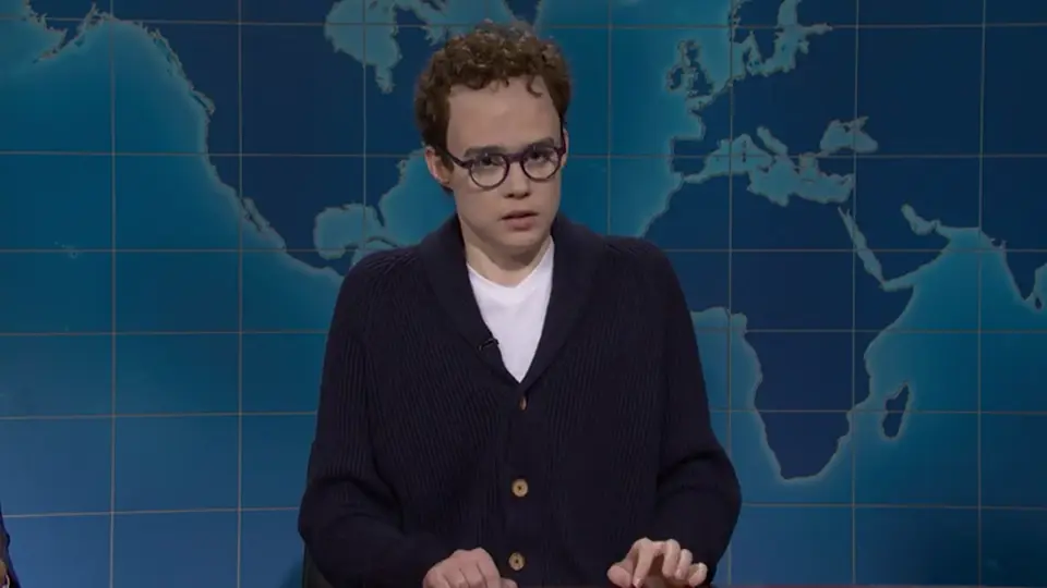 Jane Wickline as Dario Amodei gesturing while speaking at the Weekend Update desk