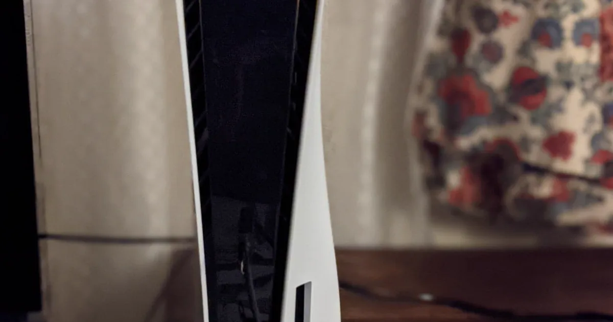 PlayStation 5 console standing vertically with a DualSense controller