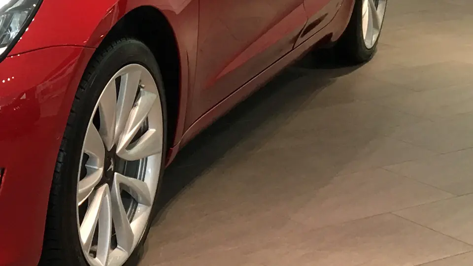Detail of a Tesla Model 3 headlight — Full Self-Driving interest is the growth story analysts are watching