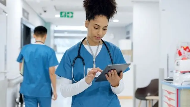 A doctor using a tablet in a clinical setting.